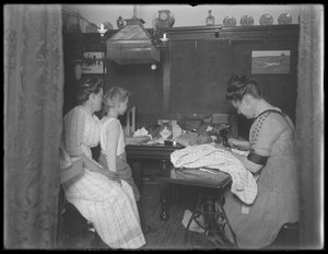 Ethel Gray Magaw Hassler, William Gray Hassler (petit garçon), Harriet E. Hassler (utilisant une machine à coudre) et Reddy (chat) dans la salle à manger de 150 Vermilyea Avenue, Appartement 44, New York, vers 19 - William Davis Hassler